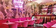 Ginny's Cocktail Lounge with pink chairs and jungle themed walls