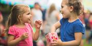 Pair of young girls sharing a box of popcorn