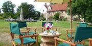 Picnic tables and chairs situated in front of the main house.