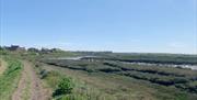 View of mud flats over the River Crouch with houses in the distance.