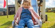 Little girl sliding down a slide