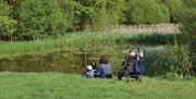 A woman and her child fish in a pond at Gilbert's Slade.