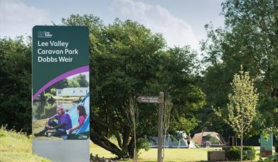 front entrance sign for Lee Valley Caravan Park Dobb Weir located on a  grassy bank