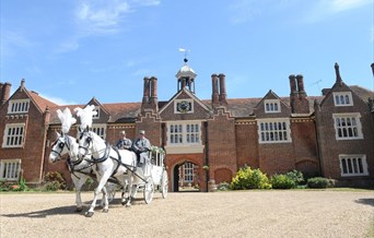 A horse-drawn carriage leaving Gosfield Hall following a wedding.