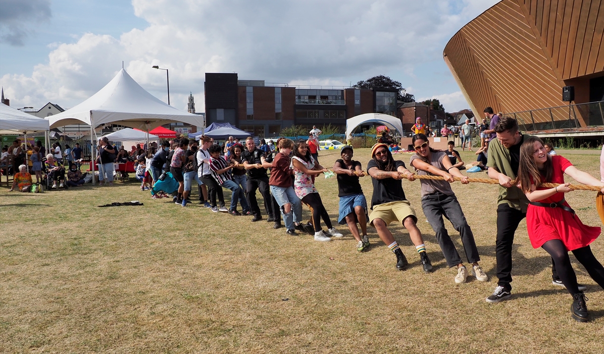 A line of people play tug of war. A line of people play tug of war.