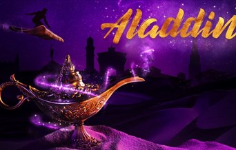 Aladdin rides his magic carpet in the distance, behind a magic lamp