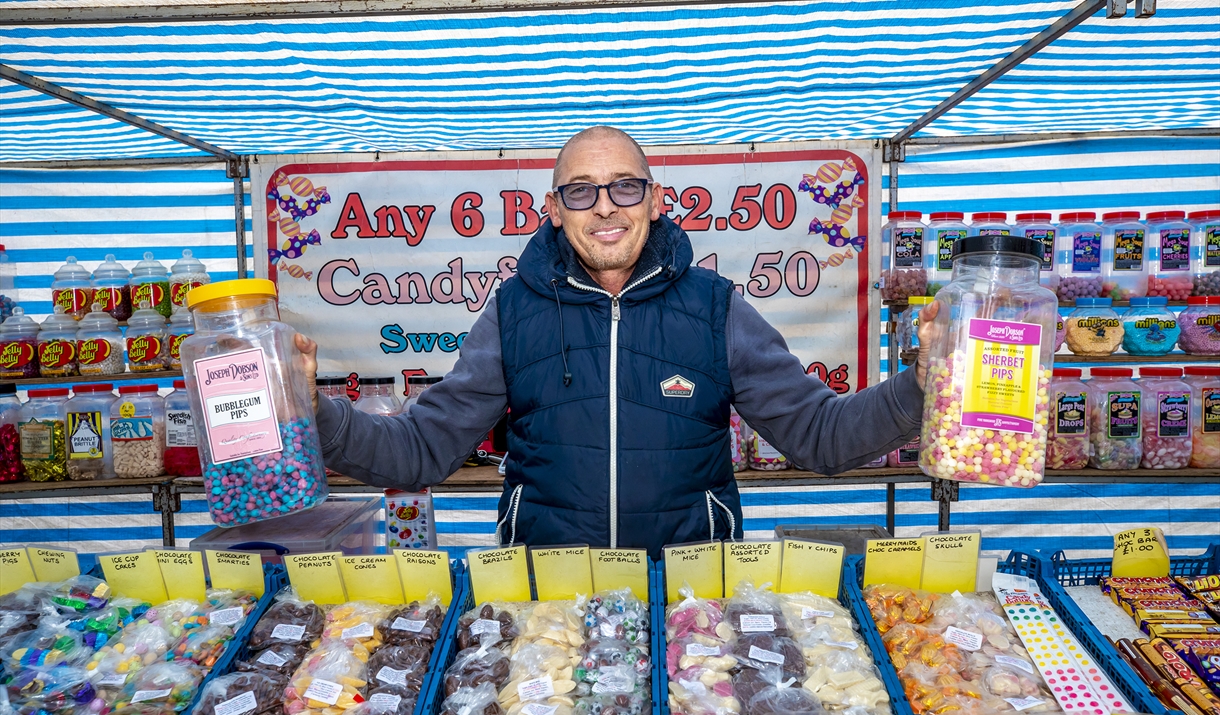 Braintree Market sweet stall with person holding sweets - Image
