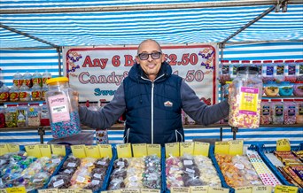 Braintree Market sweet stall with person holding sweets - Image