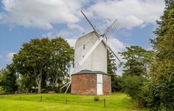 Bocking Windmill in spring with green grass in front and blue skies behind