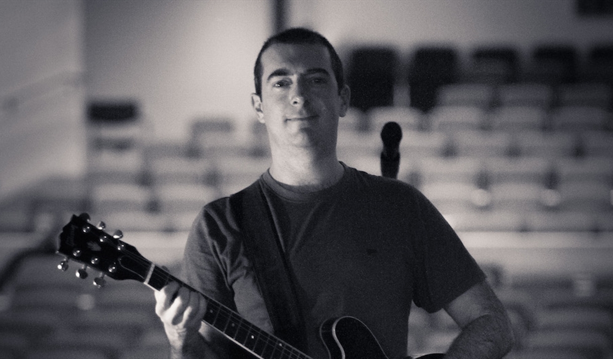 Chris Allard holding a guitar