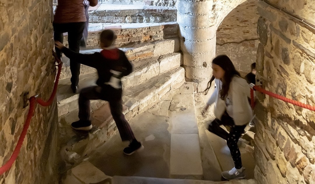 Children climbing up a stone spiral staircase