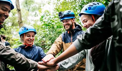 Group of smiling adults doing team builidng outdoors