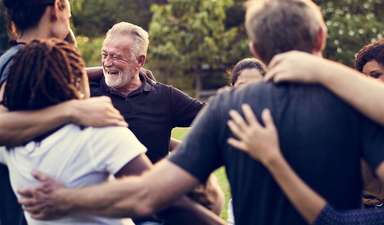 Group of smiling adults doin team builidng outdoors