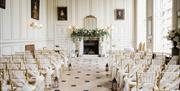 The Grand Salon set up for a wedding ceremony. It has a high hand-painted ceiling with double-height sash windows.