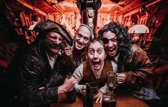 4 pirates drinking in the galley of a ship