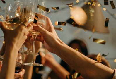 Golden confetti showering on party with wine glasses