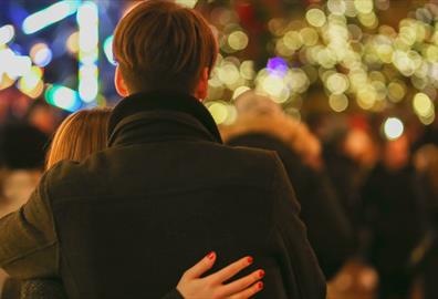 Couple looking out over Christmas outdoor gathering