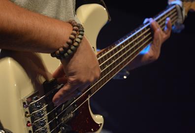 Person playing a white electric guitar