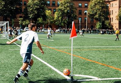 Man playing in a football match doing a corner kick