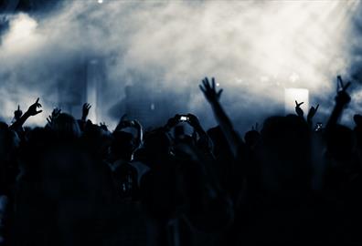 Grey and blue smoke over crowd at nightclub