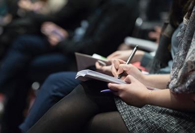 People taking notes at a lecture