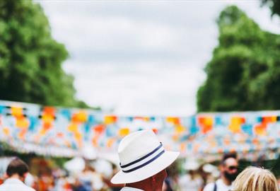 Person in white hat in front of blue and orange bunting