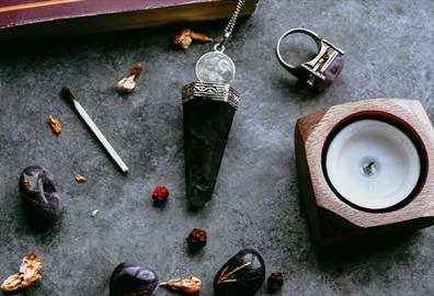 Crystals and candles on a grey marble surface