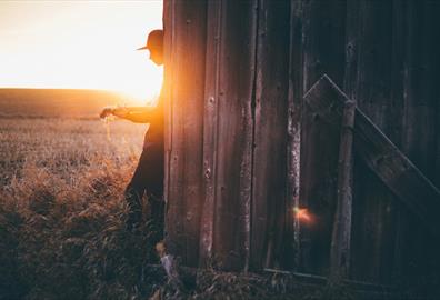 Person playing an acoustic guitar in the sunset