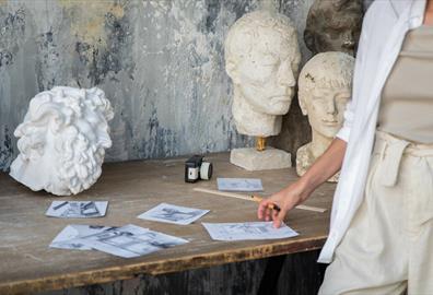 A selection of sketches and white sculptures on a table