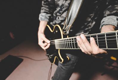 Black electric guitar being played