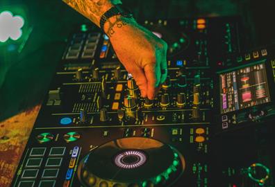 Electric mixing decks being operated by person with tattoos