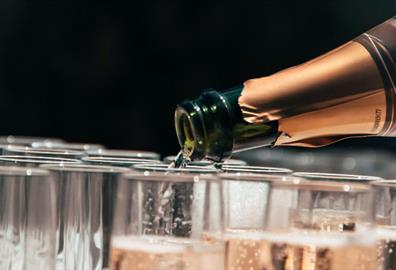 Champagne bottle pouring into glasses