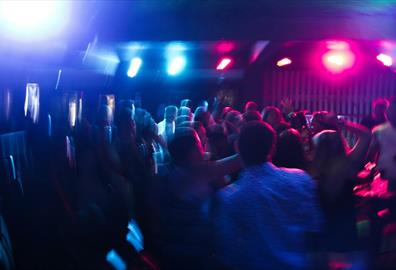 Vibrant nightclub scene with blurred dancing crowd and colorful lights