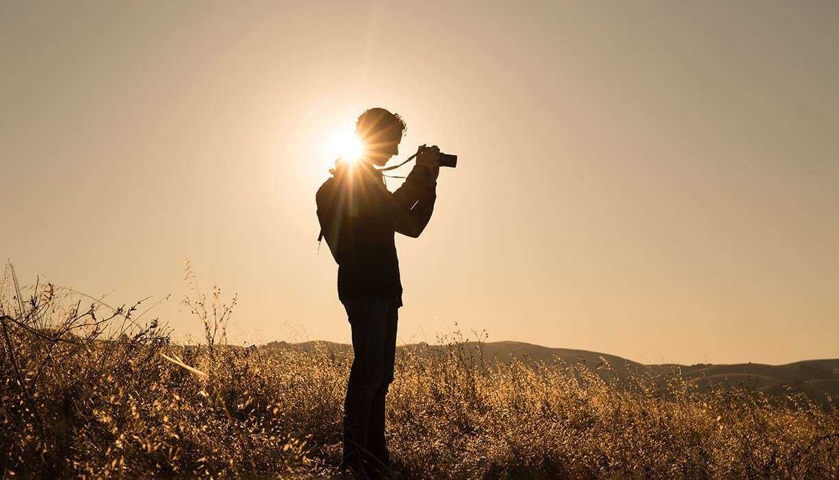 Person taking photographs in an empty field