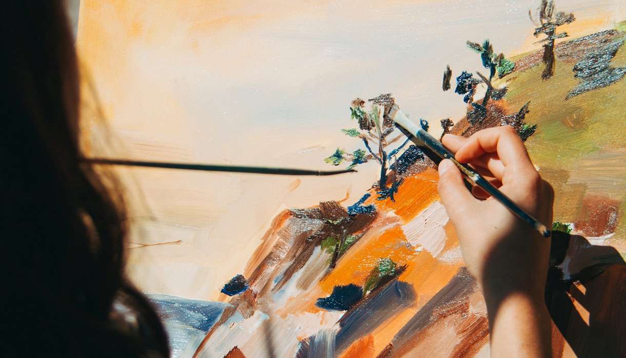 Woman painting a nature scene outside