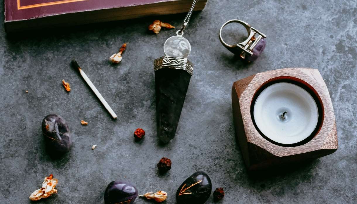 Crystals and candles on a grey marble surface