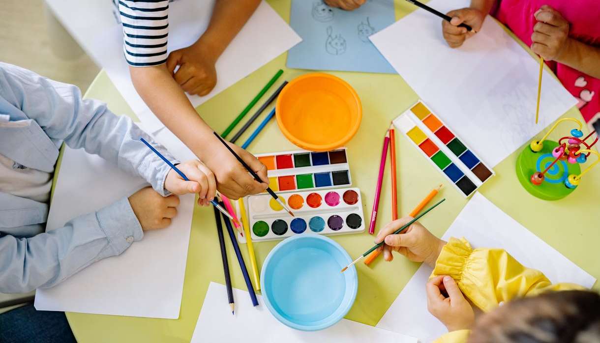 Children using pencils paint and colourful paint