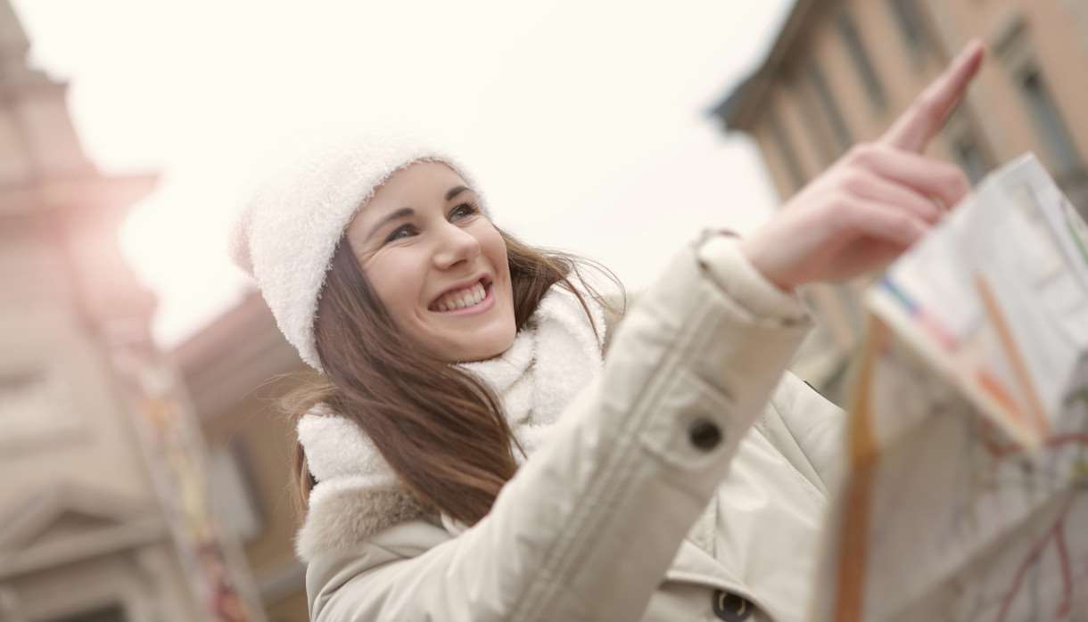 Person pointing forward in a white jacket and hat