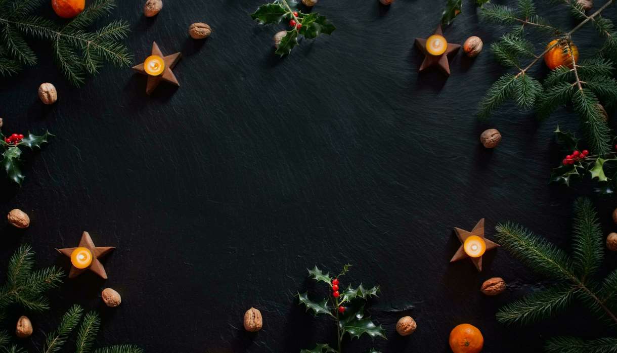 Candles and Christmas decorations on slate background