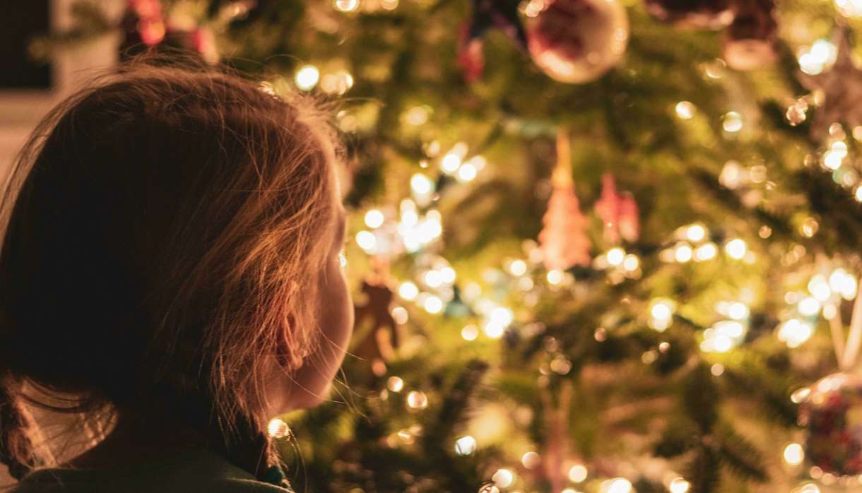 Young child looking at large indoor Christmas tree