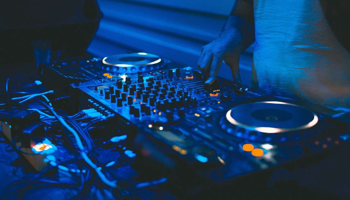 DJ and mixing decks in a blue light