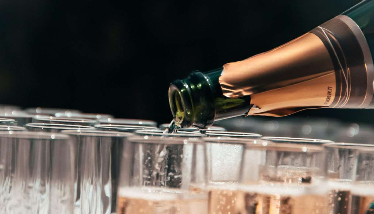 Champagne bottle pouring into glasses