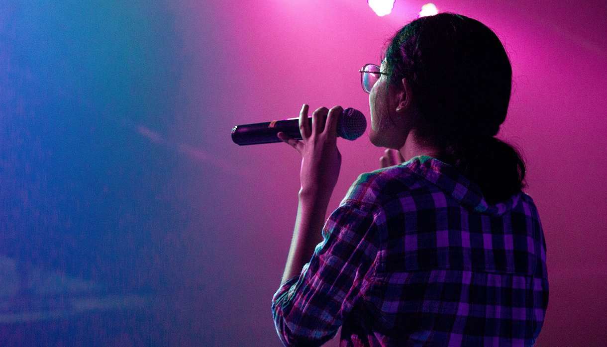 Woman onstage holding a microphone