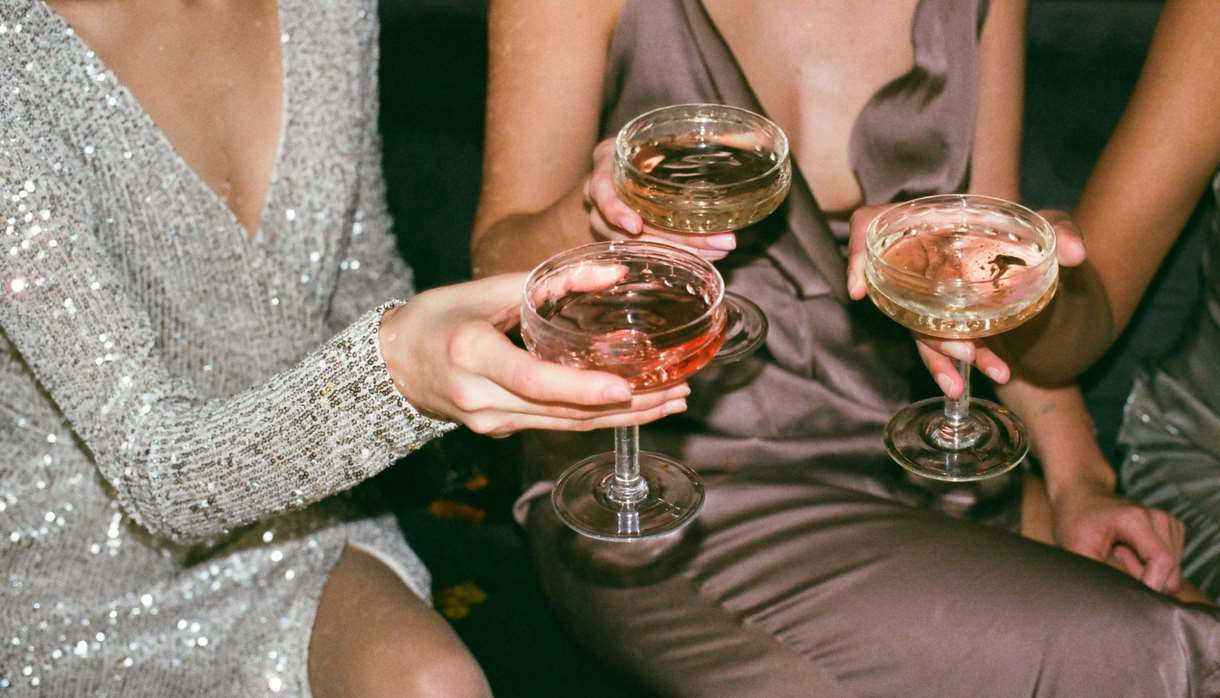 Three women in glittering dresses with shallow glasses