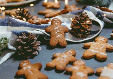 Gingerbread men surrounded with pinecones and string lights