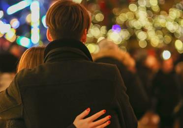Couple looking out over Christmas outdoor gathering