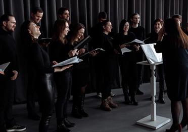 Group of people in black outfits about to sing