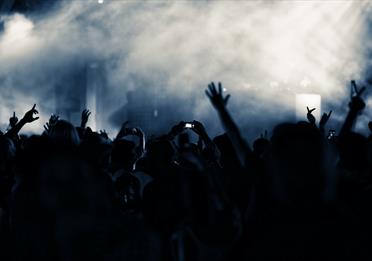 Grey and blue smoke over crowd at nightclub