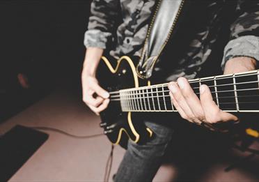 Black electric guitar being played