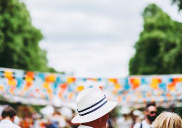 Person in white hat in front of blue and orange bunting